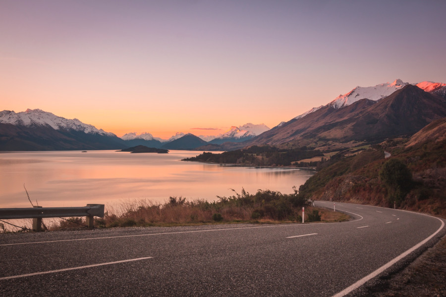 Bennetts Bluff at sunset with Lake Wakatipu and mountains in the background under a pink and orange sky